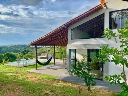 una casa con un'amaca all'esterno di RANCHO NATURE piscina e hidromassagem no LAGO CORUMBÁ 4 ALEXANIA a Alexânia