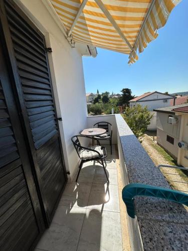 a patio with a table and chairs on a balcony at Apartments Milena in Rtina