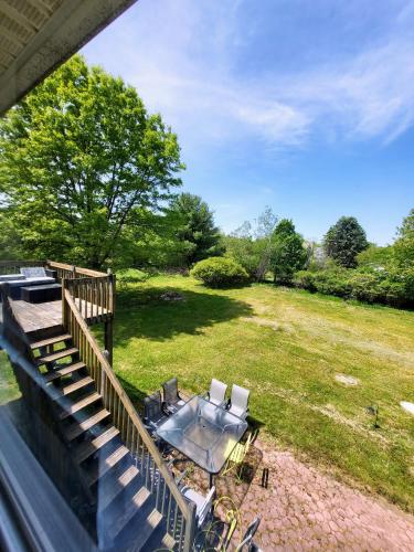 a patio with a table and chairs in a field at Cozy House in Long Pond 3 bedrooms 10 people in Long Pond