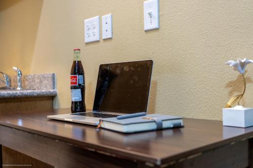 a laptop computer on a table with a bottle of beer at Texas Bungalows Hotel & Hotel Que at Lakeline Austin Cedar Park in Cedar Park