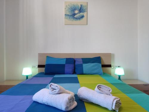 a bedroom with a colorful bed with towels on it at Mi Rinconcito de El Manantial in El Puerto de Santa María
