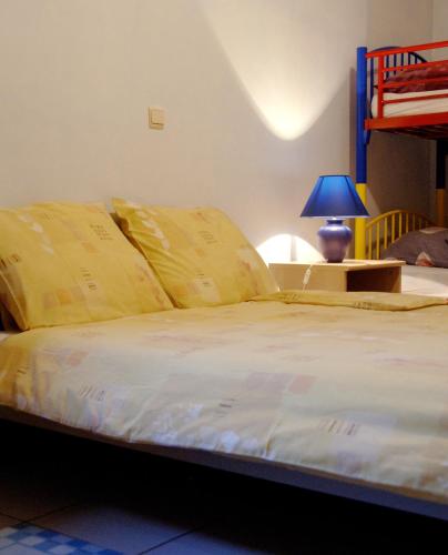 a bed with yellow pillows and a table with a lamp at Filippus Vakantiehoeve in Maldegem