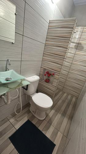a bathroom with a toilet and a sink at Casa com motorista somente pra cop 30 in Ananindeua