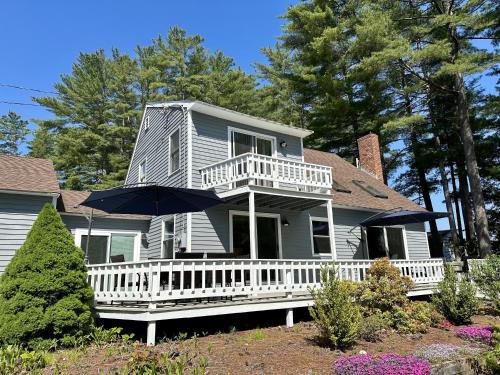 a house with an umbrella on the front porch at Sunrise Bay in Alton Bay