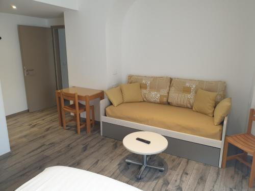 a living room with a couch and a table at Logis Hotel Restaurant Le Faudé in Lapoutroie