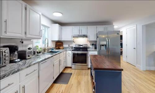 a kitchen with white cabinets and a wooden counter top at Sunrise Bay in Alton Bay