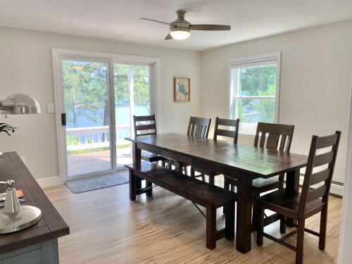 a dining room with a wooden table and chairs at Sunrise Bay in Alton Bay
