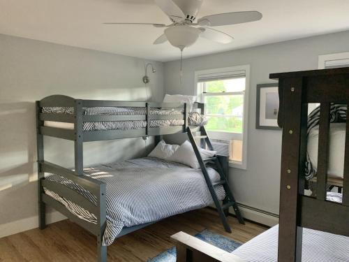 a bedroom with two bunk beds and a ceiling fan at Sunrise Bay in Alton Bay