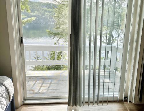 a sliding glass door with a view of a balcony at Sunrise Bay in Alton Bay