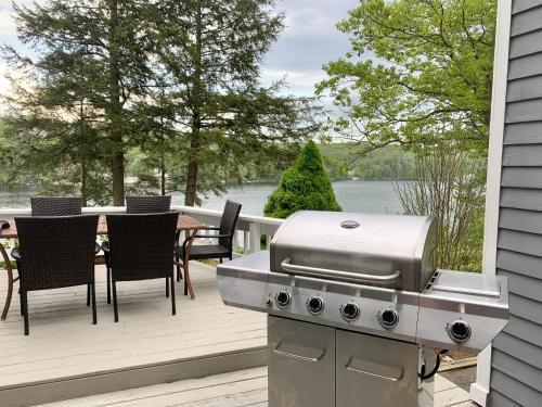 a grill on a deck with a table and chairs at Sunrise Bay in Alton Bay