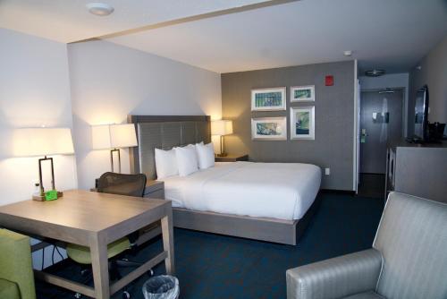 a hotel room with a large bed and a desk at La Quinta by Wyndham St. Paul-Woodbury in Woodbury