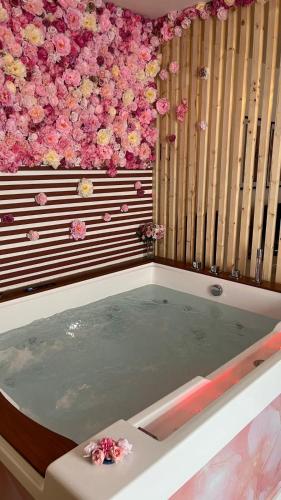 a jacuzzi tub with pink flowers on the wall at Apparemment jacuzzi balnéo centre de Bordeaux in Bordeaux
