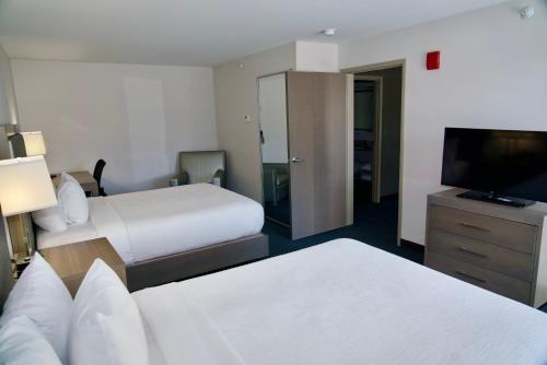 a hotel room with two beds and a flat screen tv at La Quinta by Wyndham St. Paul-Woodbury in Woodbury