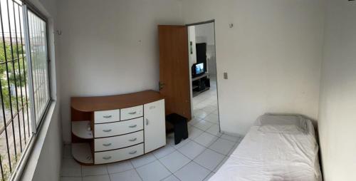 a bedroom with a bed and a dresser and a window at Apartamento Caminho da Praia in Parnaíba