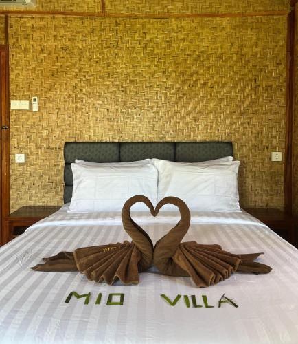 a bed with two swans in the shape of a heart at Mio Villa Tomang Omang Lombok in Selong Belanak