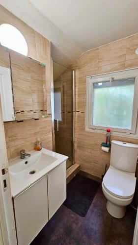 une salle de bain avec toilettes, lavabo et fenêtre dans l'établissement Chambre style hôtelière dans logement partagé, L'Executive Paris & Stade de France, à Épinay-sur-Seine