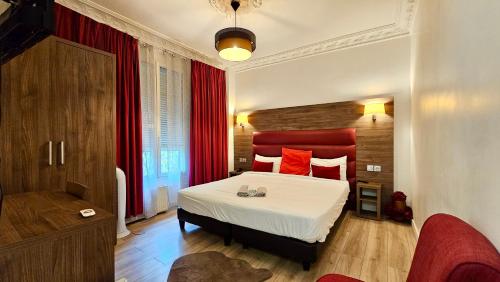 une chambre avec un grand lit avec une tête de lit rouge dans l'établissement Chambre style hôtelière dans logement partagé, L'Executive Paris & Stade de France, à Épinay-sur-Seine