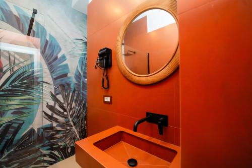 a bathroom with an orange sink and a mirror at Four Points Suites in Naples