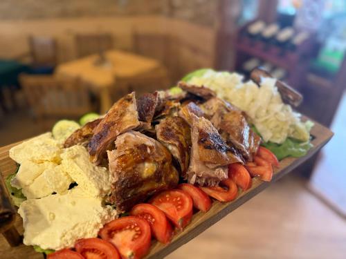 a plate of food with meat and vegetables on a table at Rooms & Spa BJELASICA in Bijelo Polje