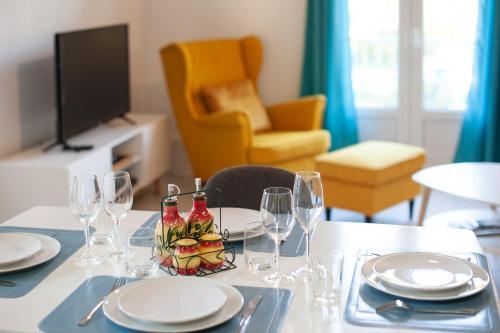 une table avec des assiettes et des verres à vin dessus dans l'établissement Beautiful & large sea view apartment, à Menton