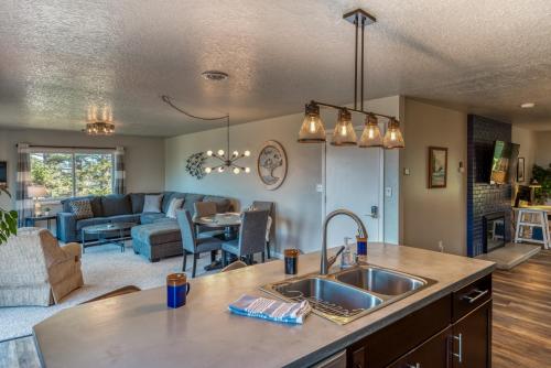 a kitchen with a sink and a living room at The Pacific Lookout Sleeps 6, Hot Tub, Pet Friendly, Ocean View, EV Charger in Salishan Beach