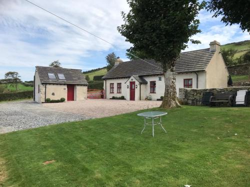a small house with a table in the yard at Mc Courts Cottage & Barn in Newry