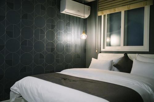 a bedroom with a large bed with white sheets at Gray hotel in Tongyeong
