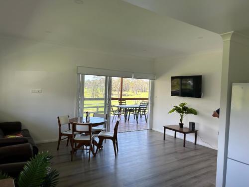 a living room with a table and chairs at Kangaroo hill in Sussex inlet
