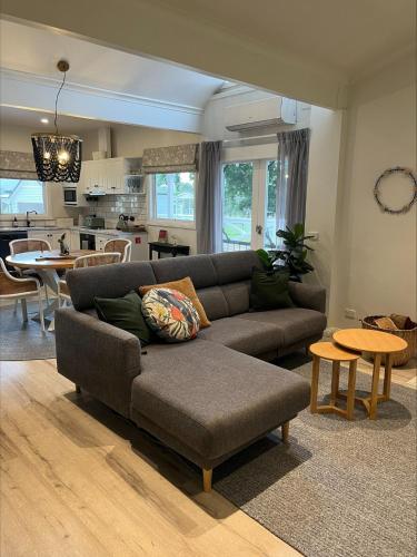 a living room with a couch and a table at Yarra Fox Farm Cottage Farmstay in Dixons Creek