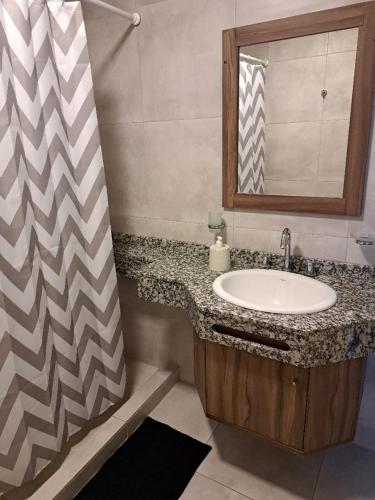 a bathroom with a sink and a shower curtain at Departamentos 1943-2 in Villa Constitución