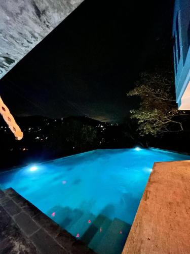 a swimming pool at night with a view at Descanso total en el mejor clima de Colombia in Anapoima