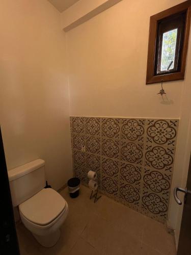 a bathroom with a toilet and a window at Pousada Borghetto – Charme e Exclusividade no Vale dos Vinhedos in Bento Gonçalves