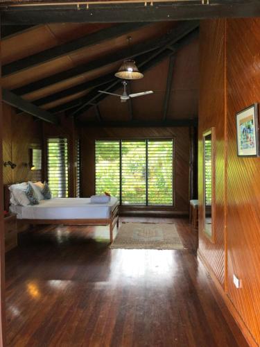 a bedroom with a bed in a room with wooden floors at Garden Of Eden in Matei