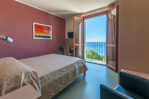 a bedroom with a bed and a large window at Oroverde in Bergeggi