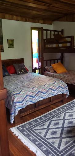 a bedroom with two beds and a rug at Papaya Wildlife Lodge in Cahuita