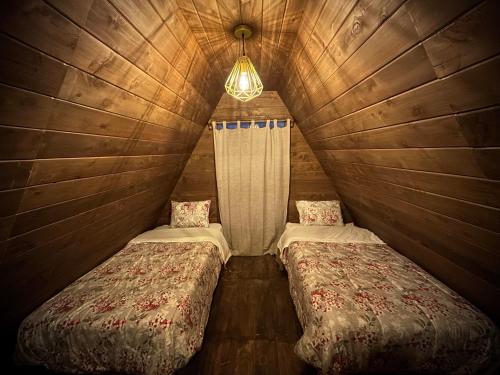 a room with two beds in a wooden cabin at La Encantad Cabañas - Amanecer in Cajamarca