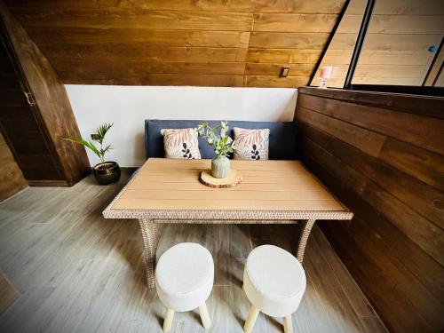 a small table and two stools in a room at La Encantad Cabañas - Amanecer in Cajamarca