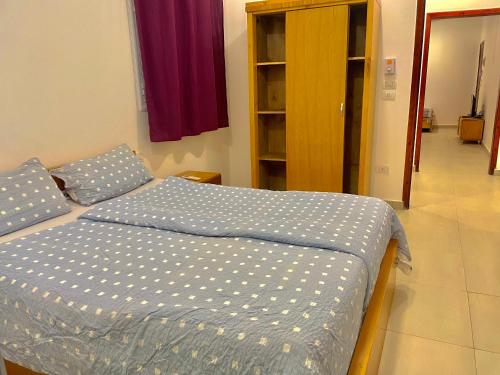 a bedroom with a bed with a blue comforter at Nile Panorama Hotel in Luxor