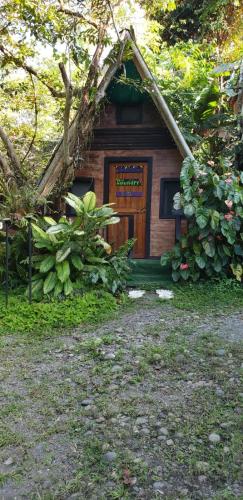 a small house with a wooden door in a yard at Papaya Wildlife Lodge in Cahuita