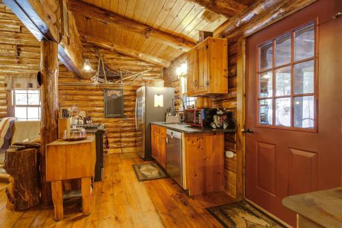 a kitchen with wooden walls and a red door at Lake and Beach Access at Lake Luzerne Cabin! in Lake Luzerne