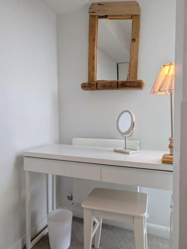 a white desk with a mirror and a stool at Modern Apartment By The Beach in Newquay