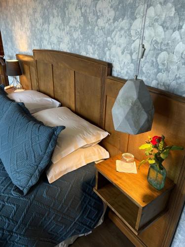 a bedroom with a bed with a table with a lamp at Pousada Borghetto – Charme e Exclusividade no Vale dos Vinhedos in Bento Gonçalves