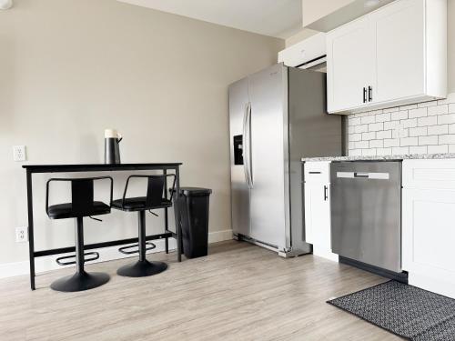 a kitchen with a table and a refrigerator at RiverStone Retreat - Newburgh IN Stylish Apartments in Newburgh