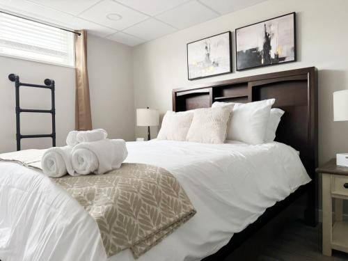 a bedroom with a large white bed with towels on it at RiverStone Retreat - Newburgh IN Stylish Apartments in Newburgh