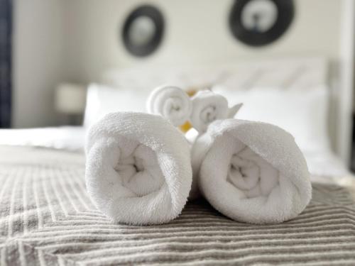 a pair of towels sitting on top of a bed at RiverStone Retreat - Newburgh IN Stylish Apartments in Newburgh