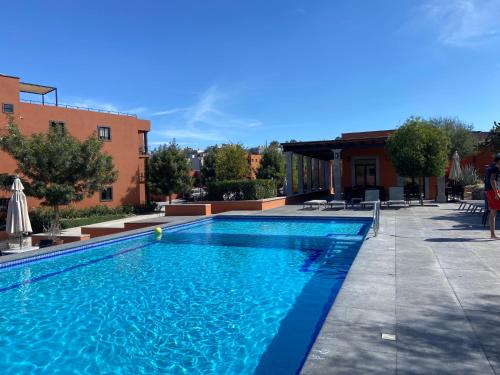 a swimming pool with blue water in a yard at EL Colibrí in San Miguel de Allende