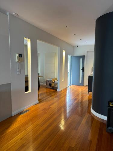 una sala de estar vacía con suelo de madera dura en A luxury home in Oakleigh, en Oakleigh