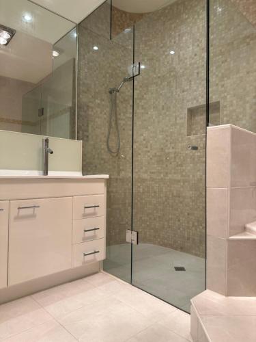 a bathroom with a shower with a glass door at A luxury home in Oakleigh in Oakleigh