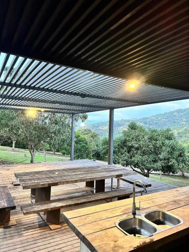 a wooden picnic table with a sink on a deck at Descanso total en el mejor clima de Colombia in Anapoima