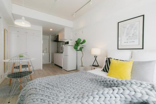 a bedroom with a large bed with a yellow pillow at 5A Guest House INFINITY in Naha